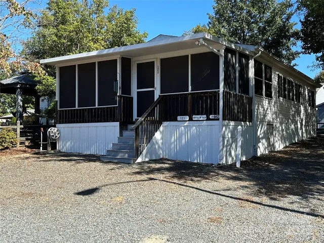 a view of wooden house with a yard