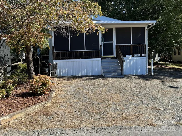 a view of a house with a tree and wooden fence