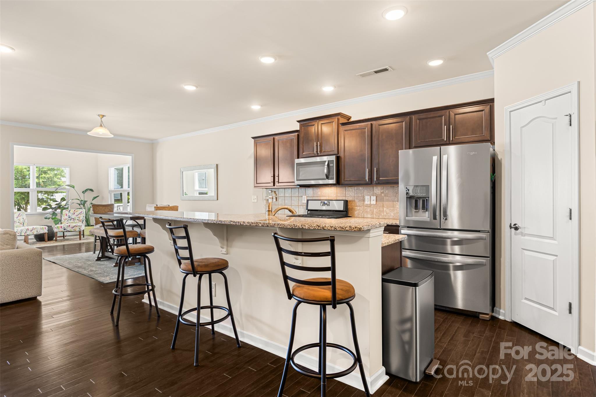 269 Keating Pl Drive Fort Mill, SC 29708 - Photo 15 of 48 a kitchen with stainless steel appliances a refrigerator a stove a dining table and chairs with wooden floor
