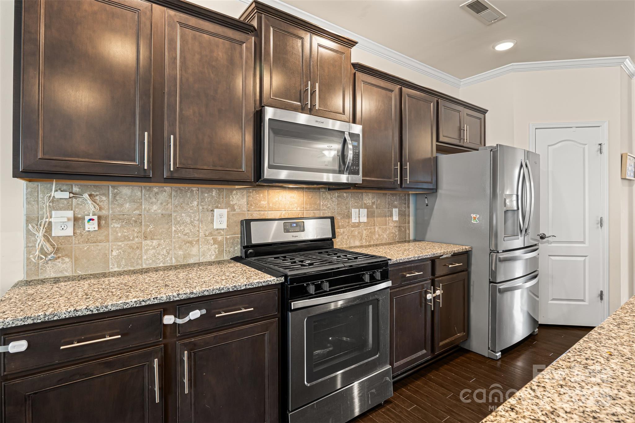 269 Keating Pl Drive Fort Mill, SC 29708 - Photo 18 of 48 a kitchen with stainless steel appliances granite countertop a stove a refrigerator and a sink
