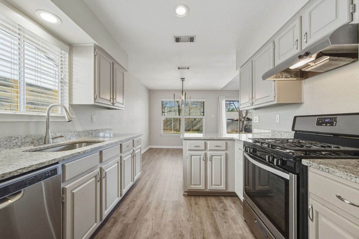 4615 Sidereal Drive Austin, TX 78727 - Photo 10 of 40 Entertaining is easy in the kitchen featuring gas cooking, stainless steel appliances, and granite countertops.