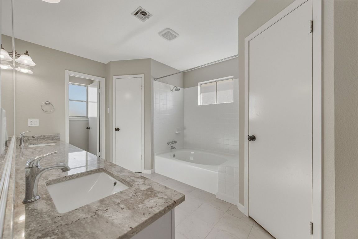 4615 Sidereal Drive Austin, TX 78727 - Photo 13 of 40 Full bath featuring tub / shower combination, double vanity, and spacious walk-in closets