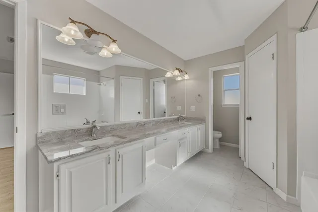 a spacious bathroom with a granite countertop tub sink and mirror