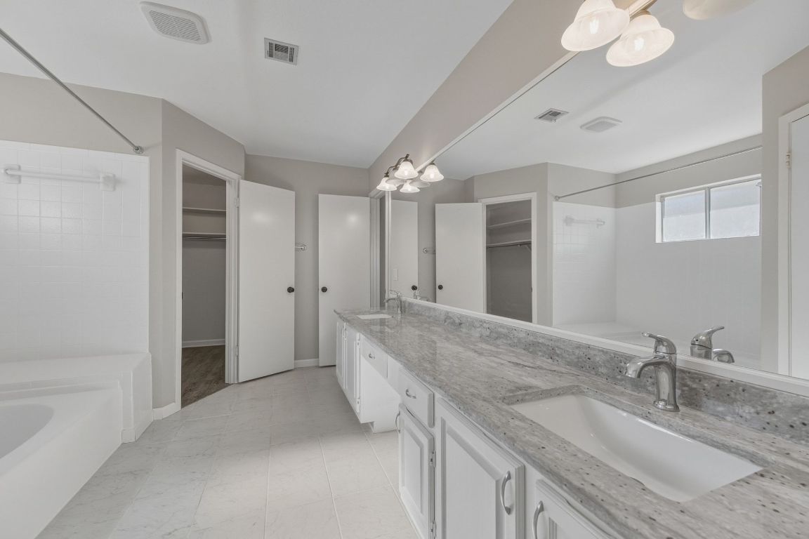 4615 Sidereal Drive Austin, TX 78727 - Photo 15 of 40 Full bath featuring tub / shower combination, double vanity, and spacious walk-in closets