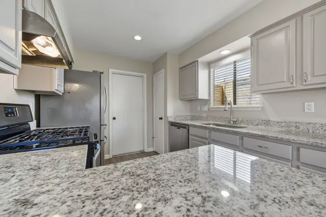 a kitchen with a stove sink and cabinets