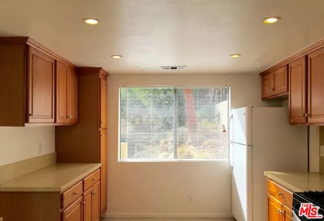 a kitchen with refrigerator cabinets and wooden floor