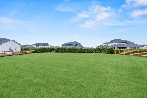 a view of green field with house in the background