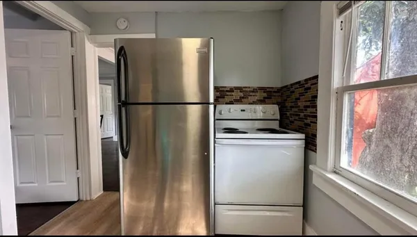 a kitchen with stainless steel appliances a refrigerator and a window