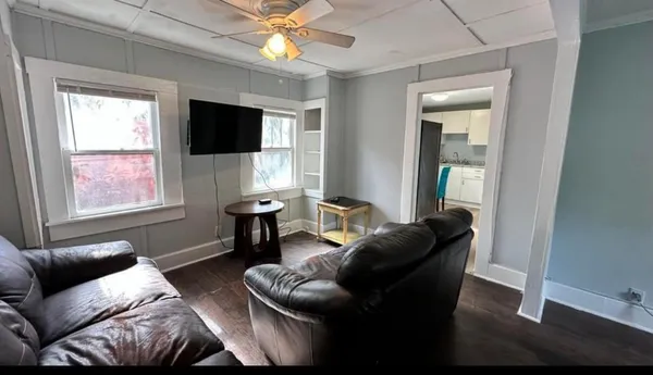 a living room with furniture a flat screen tv and a window