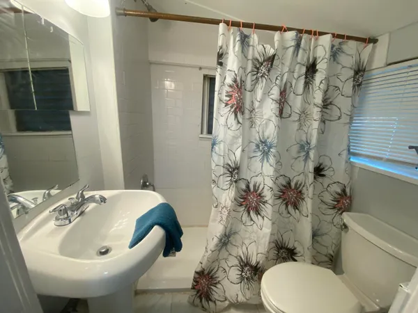 a bathroom with a sink and mirror with toilet