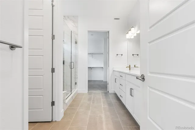 a bathroom with a double vanity sink mirror and shower