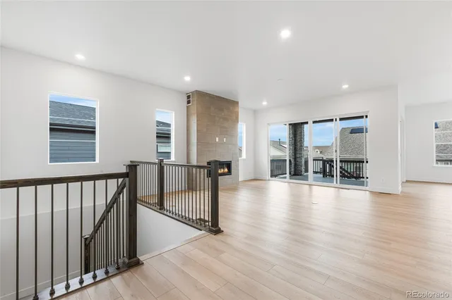 a view of a hall with wooden floor and windows