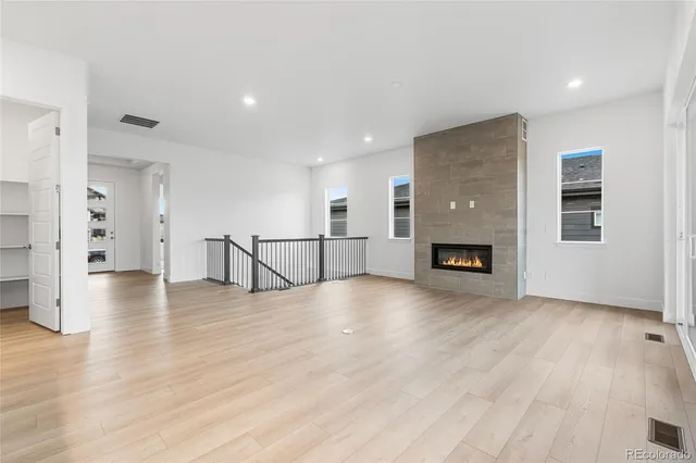 a view of empty room with wooden floor and fireplace