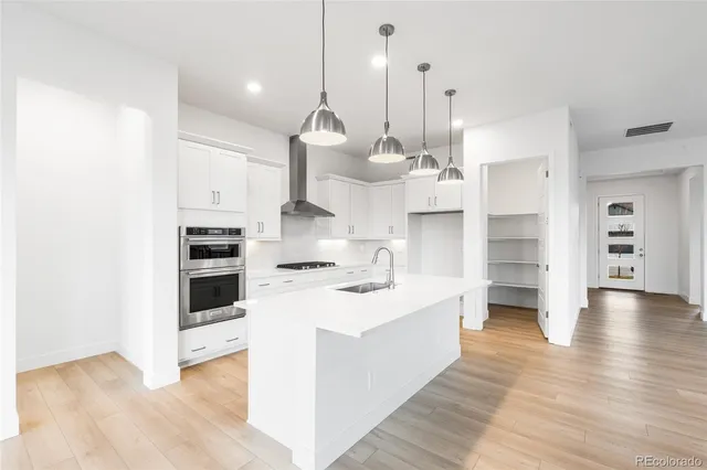 a large kitchen with white cabinets and stainless steel appliances