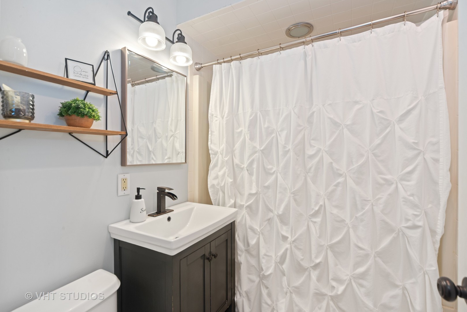 230 West Harrison Road Lombard, IL 60148 - Photo 22 of 31 a bathroom with a sink a mirror and a shower curtain
