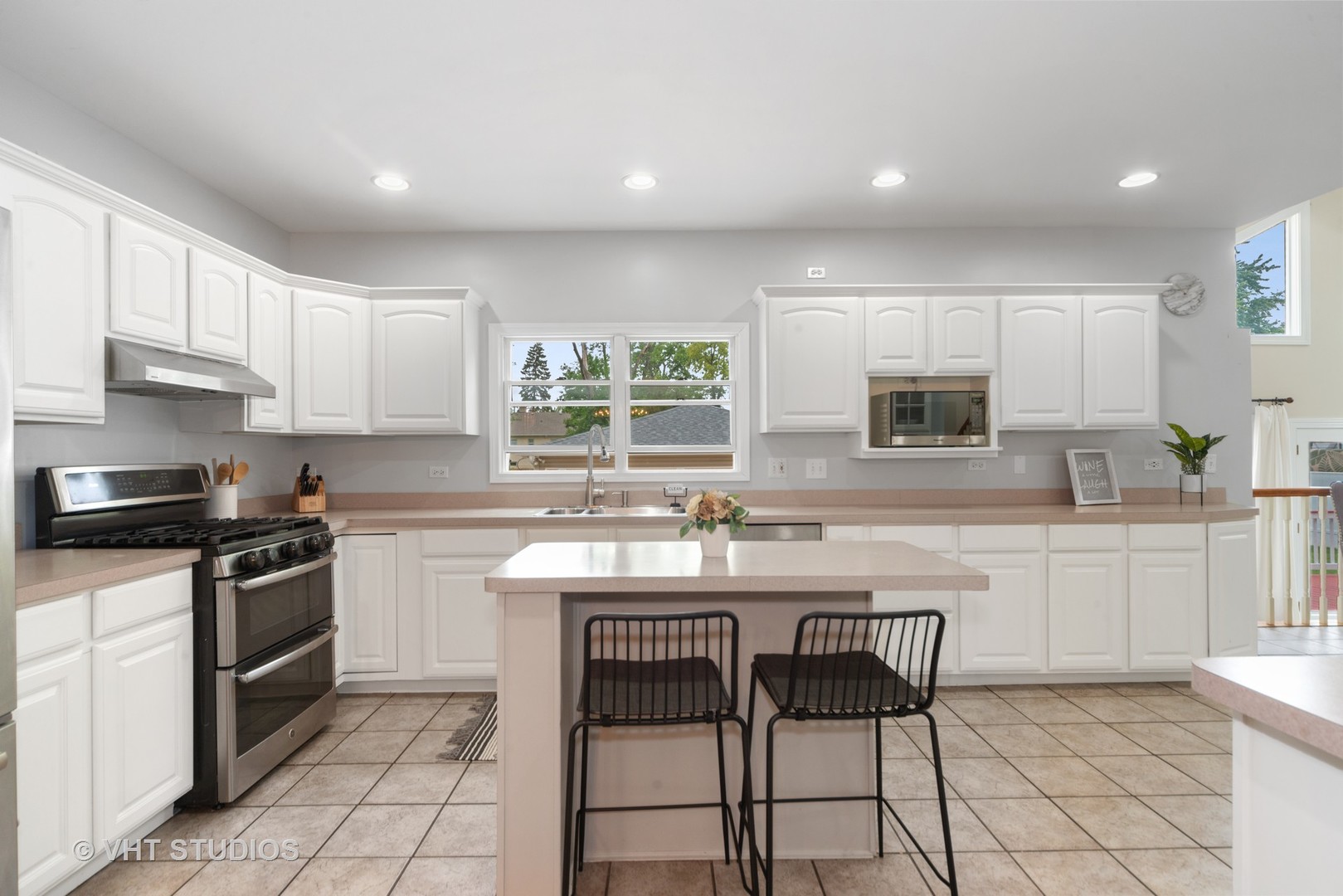 230 West Harrison Road Lombard, IL 60148 - Photo 7 of 31 a kitchen with stainless steel appliances granite countertop a stove a sink dishwasher a stove and white cabinets with wooden floor