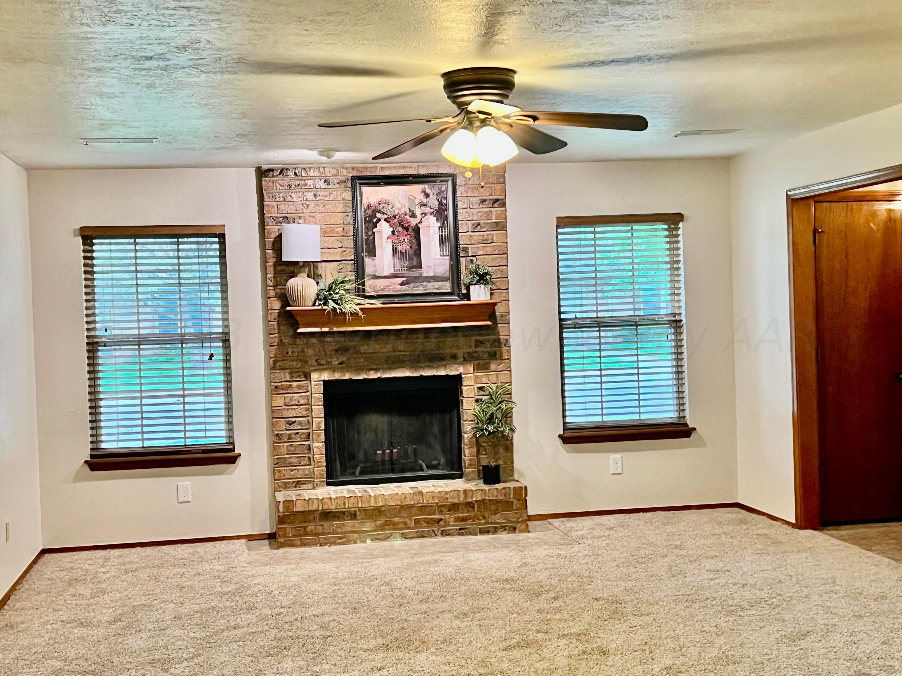 3416 B Gladstone Lane Amarillo, TX 79121 - Photo 3 of 17 a view of an empty room with a fireplace and a window