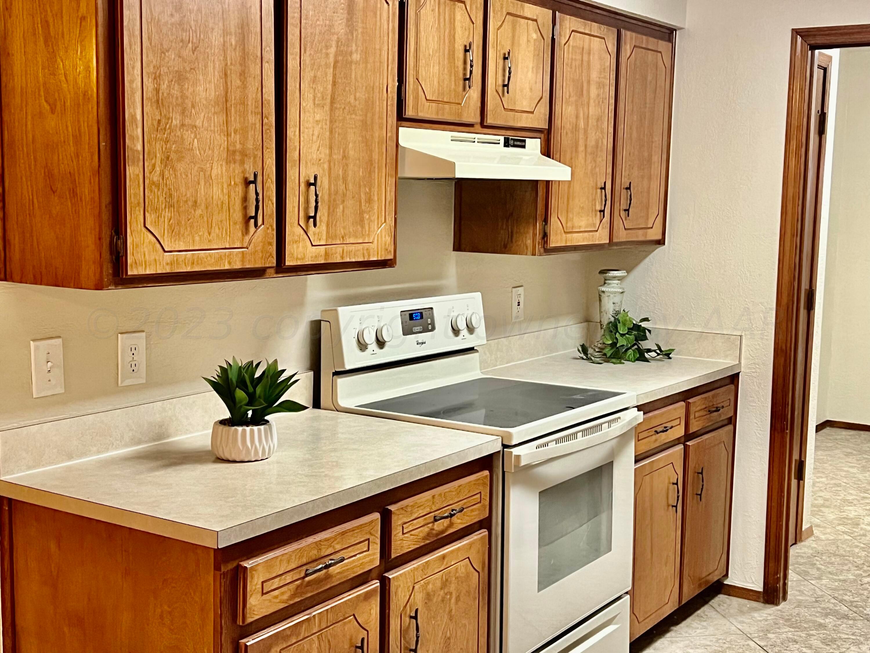 3416 B Gladstone Lane Amarillo, TX 79121 - Photo 5 of 17 a kitchen with stainless steel appliances granite countertop a sink a stove and white cabinets