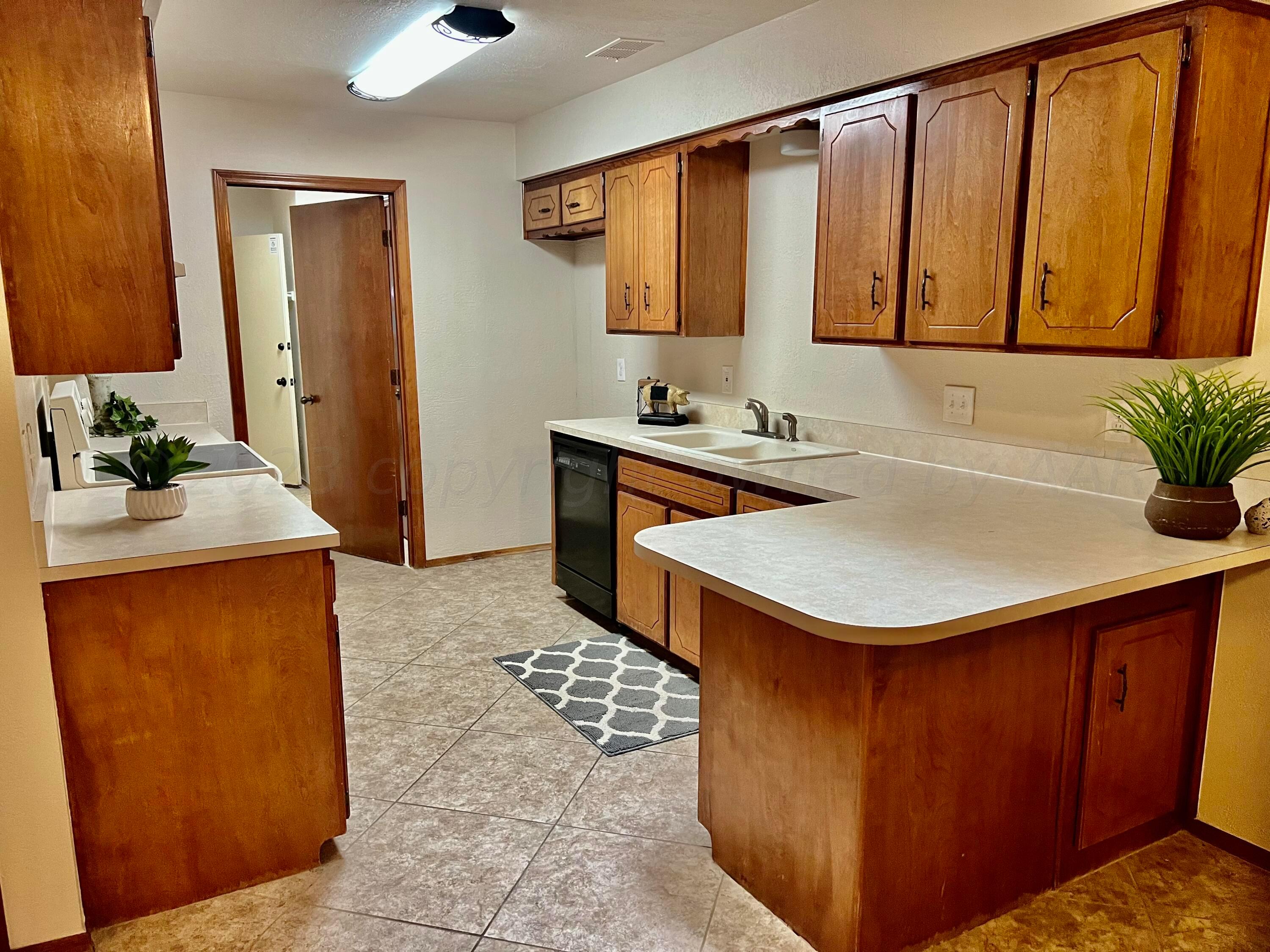 3416 B Gladstone Lane Amarillo, TX 79121 - Photo 7 of 17 a kitchen with stainless steel appliances a sink a microwave a stove and white cabinets