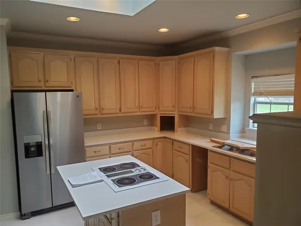 a kitchen with a sink a refrigerator and cabinets
