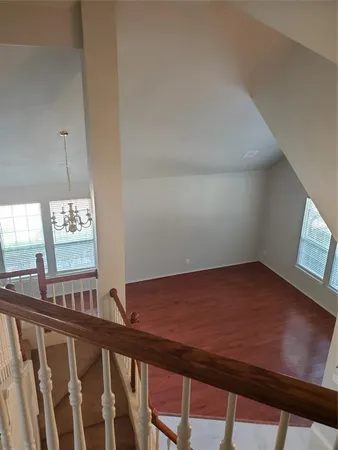 a view of a room with a window and wooden floor