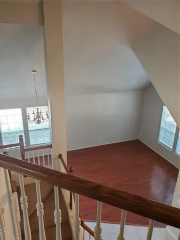 a view of a room with a window and wooden floor