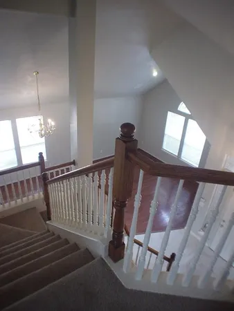 a view of staircase with black carpet