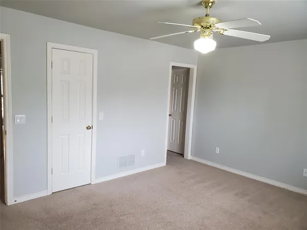 an empty room with a chandelier fan