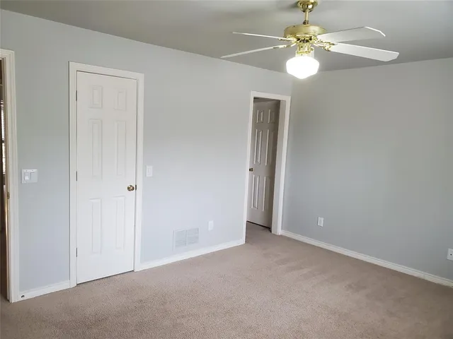 an empty room with a chandelier fan