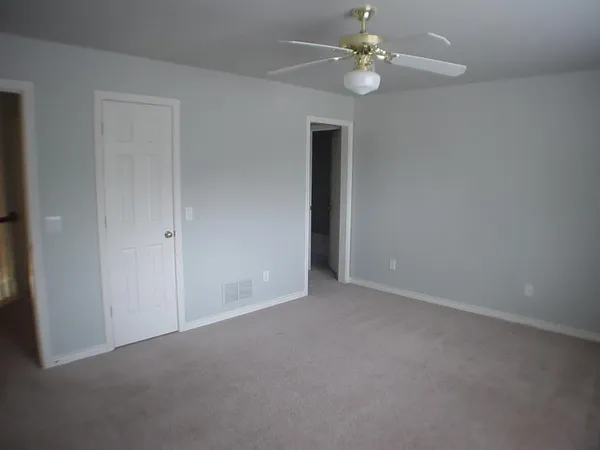 a view of an empty room with a ceiling fan