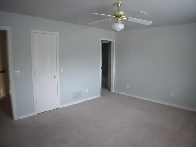 a view of an empty room with a ceiling fan
