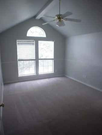 en empty room with windows and ceiling fan