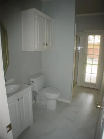 a bathroom with a sink a toilet and window