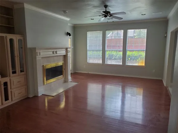 a view of a livingroom with a fireplace window and wooden floor