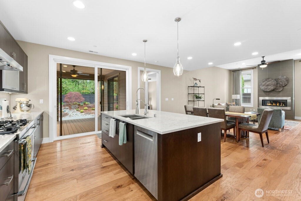 6578 Serenity Loop Gig Harbor, WA 98335 - Photo 12 of 38 a large kitchen with kitchen island a sink a stove a dining table and chairs