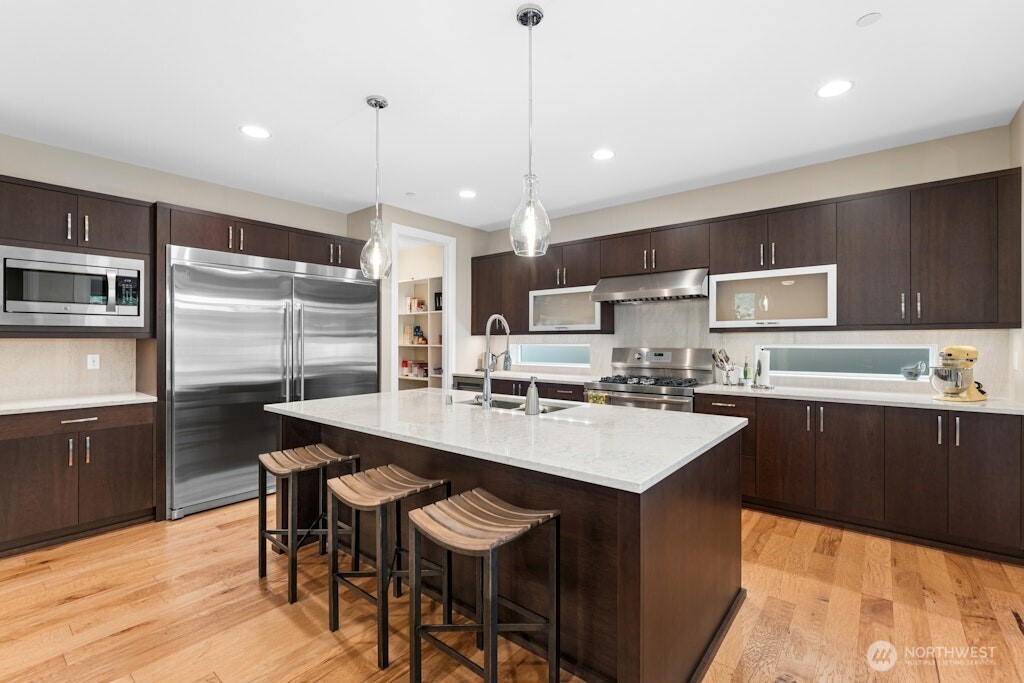 6578 Serenity Loop Gig Harbor, WA 98335 - Photo 10 of 38 a kitchen with stainless steel appliances granite countertop a sink a stove a refrigerator cabinets and chairs