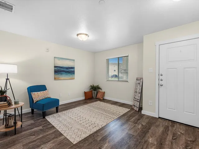 a living room with furniture and a wooden floor
