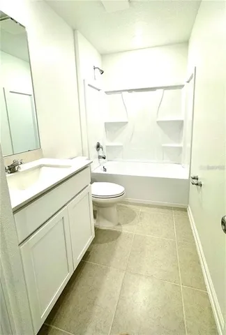 a kitchen with stainless steel appliances kitchen island a refrigerator sink and white cabinets