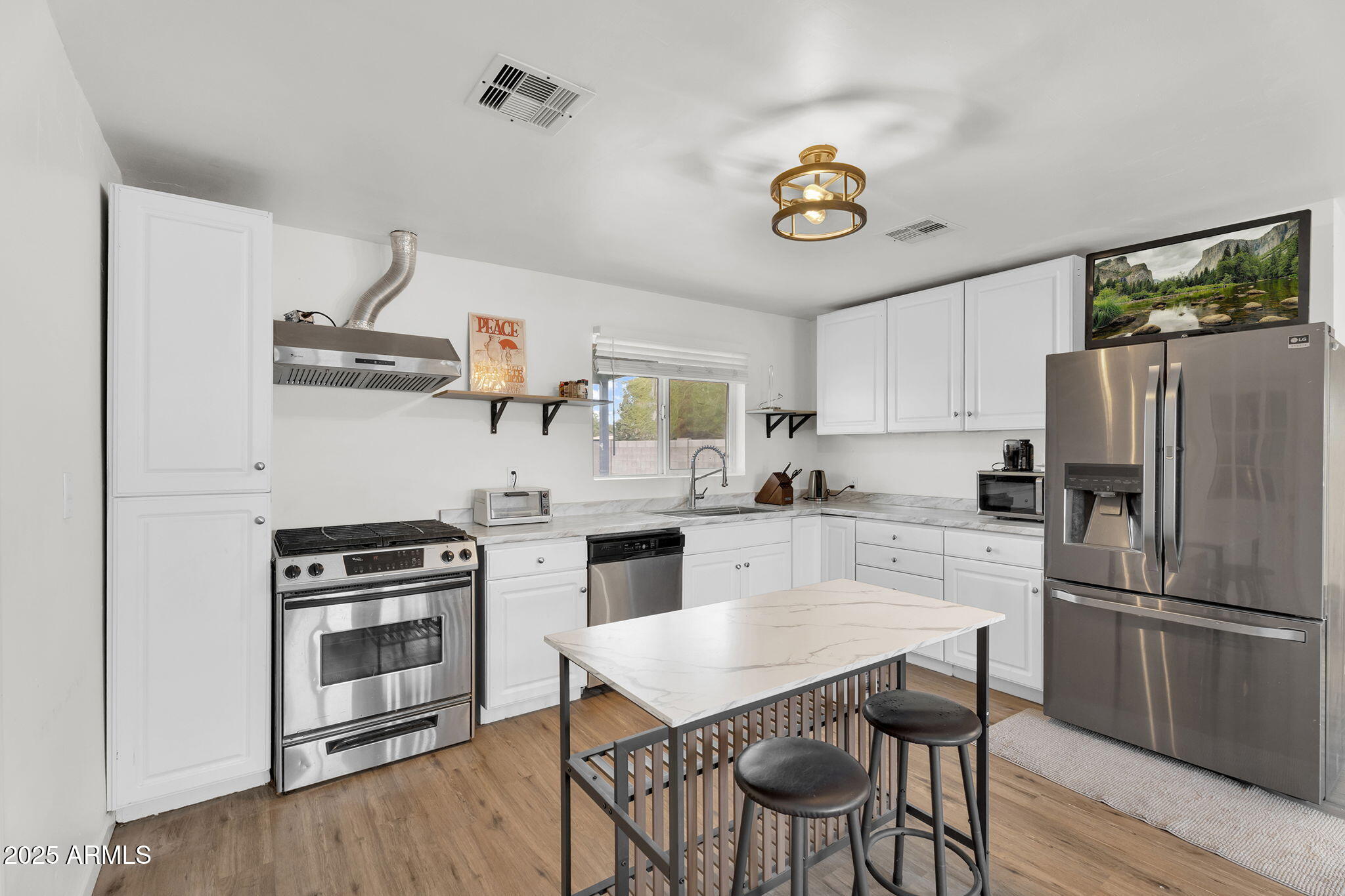 2434 North 37th Way Phoenix, AZ 85008 - Photo 6 of 17 a kitchen with stainless steel appliances a stove a refrigerator and a dining table