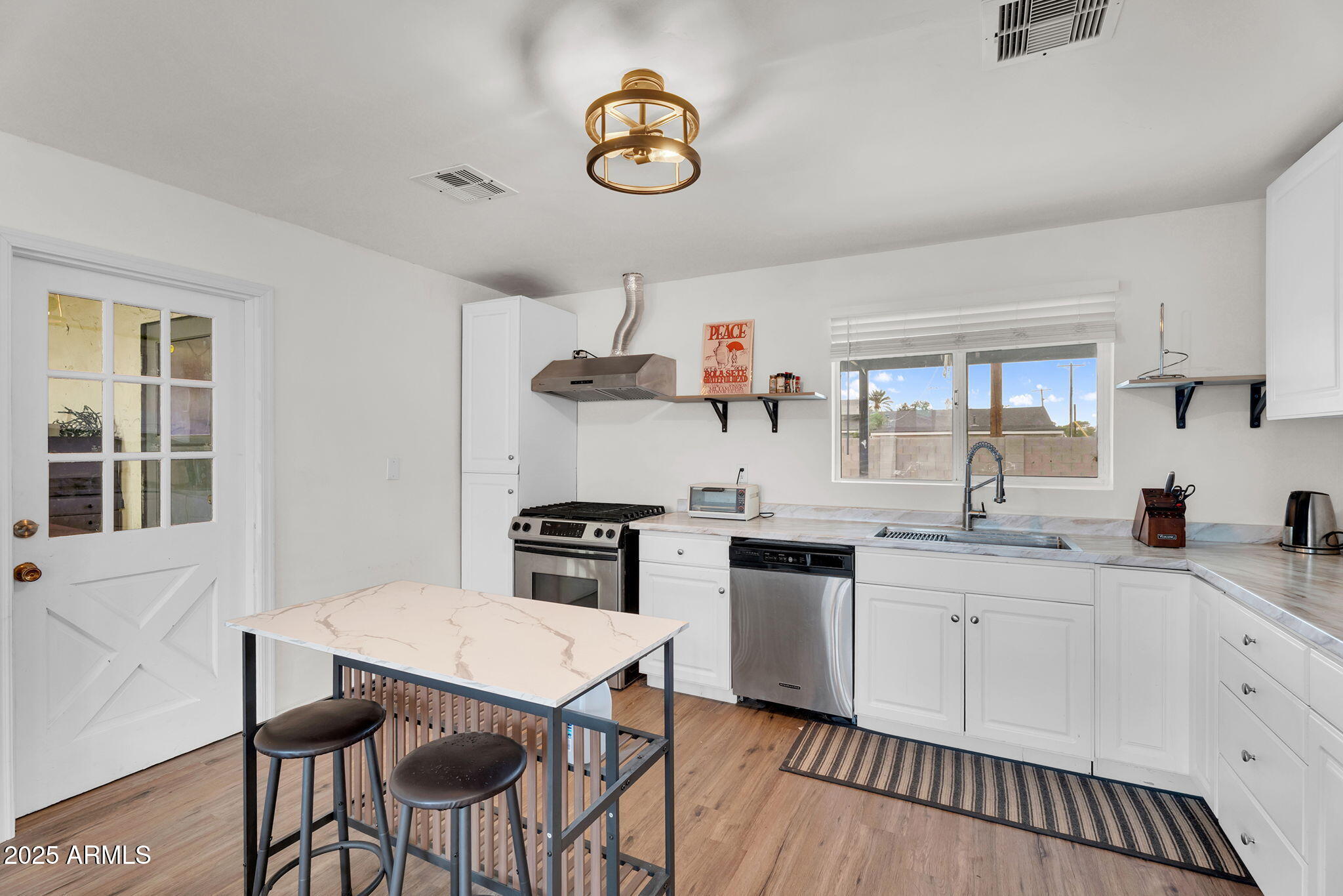 2434 North 37th Way Phoenix, AZ 85008 - Photo 7 of 17 a kitchen with granite countertop a sink a stove cabinets dining table and chairs