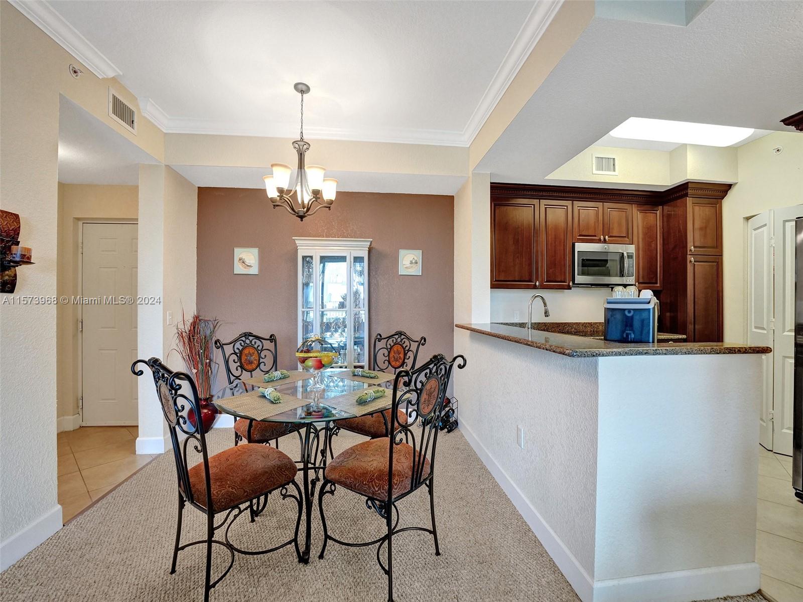 1660 Renaissance Commons Boulevard, Unit 2508 Boynton Beach, FL 33426 - Photo 9 of 28 a dining room filled chandelier and wooden floor