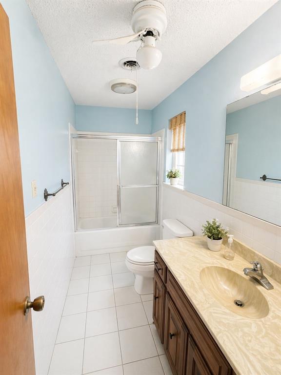 504 Aspen Road Gainesville, TX 76240 - Photo 7 of 11 Bathroom featuring a single vanity with a patterned countertop, integrated sink, and dark wood-finish cabinetry