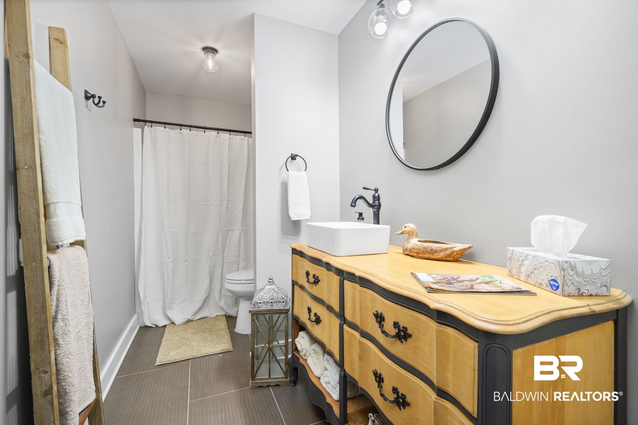 11025 Creax Road Axis, AL 36505 - Photo 30 of 45 Bathroom featuring a white vessel sink, dark-finish faucet, and a round black-framed mirror