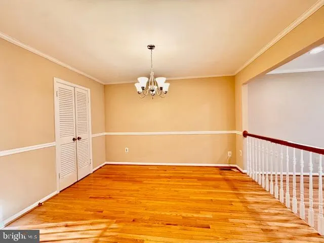 a view of a room with wooden floor and a ceiling fan