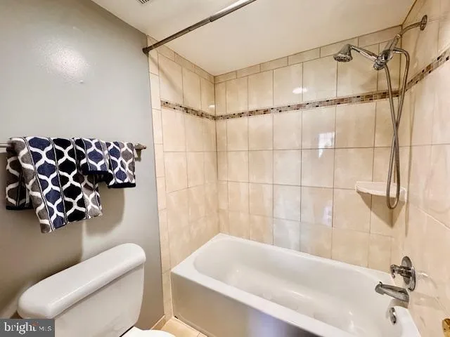 a bathroom with a toilet and a bath tub
