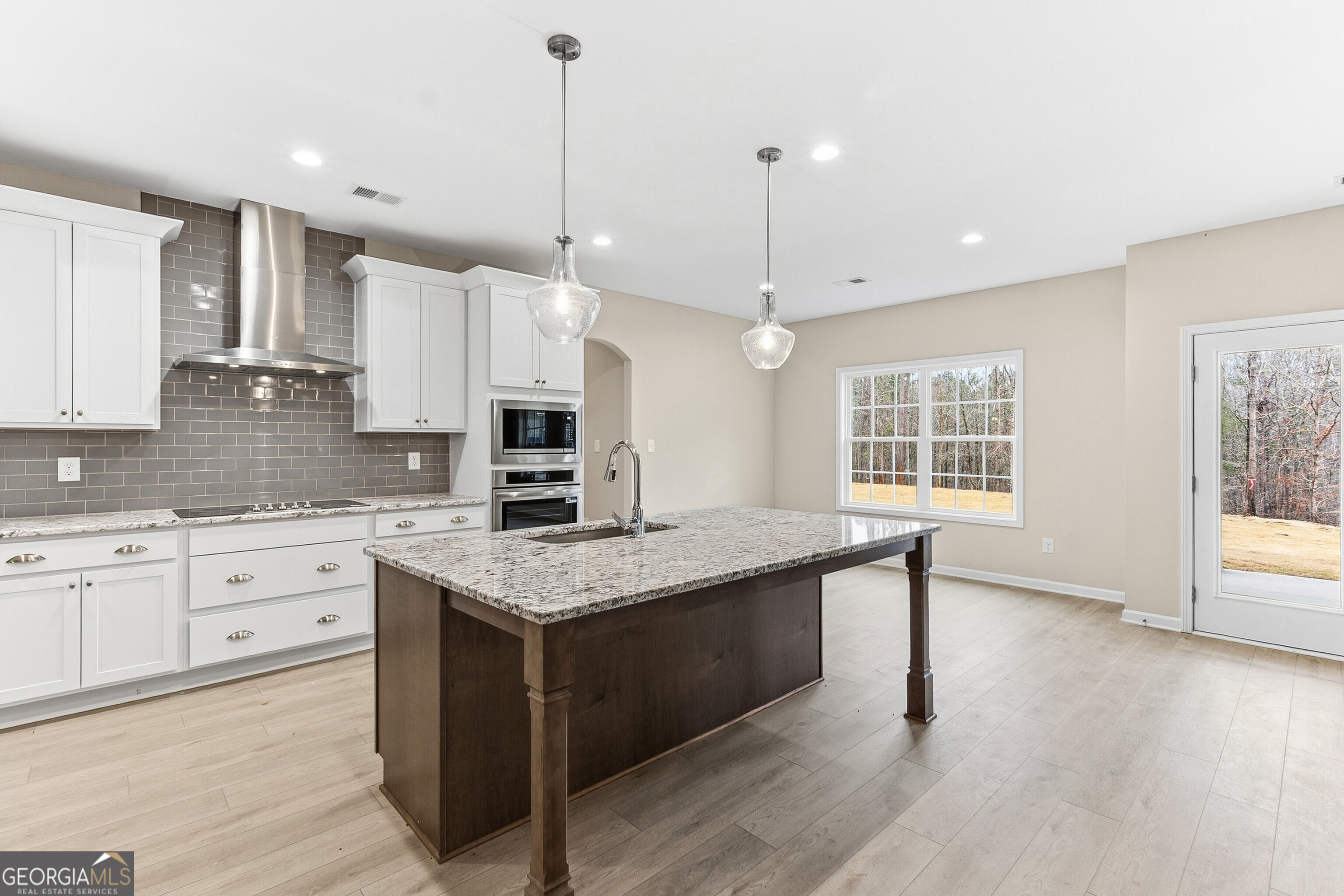 1649 Stokes Store Road, Unit 52 Forsyth, GA 31029 - Photo 25 of 73 a kitchen with stainless steel appliances granite countertop a sink a stove and a wooden floor