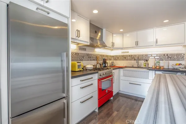 a kitchen with stainless steel appliances granite countertop a refrigerator and a stove