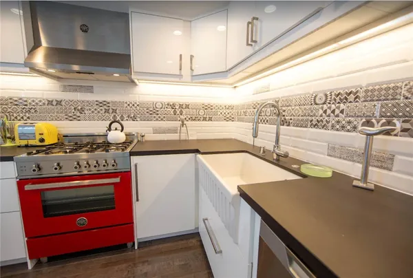 a kitchen with stainless steel appliances granite countertop a sink and a stove