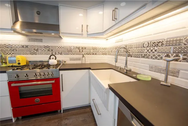 a kitchen with stainless steel appliances granite countertop a sink and a stove