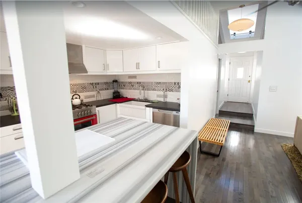 a open kitchen with white cabinets and stainless steel appliances